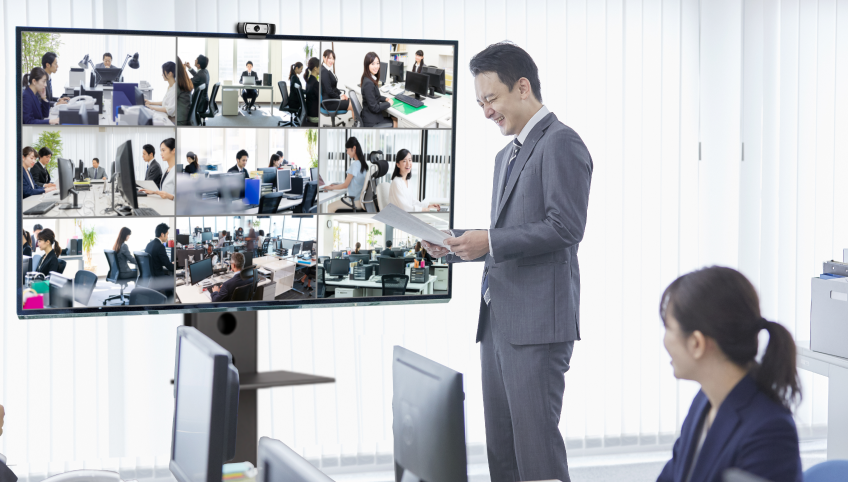 9分分割表示のモニター画面の前で話をする男性